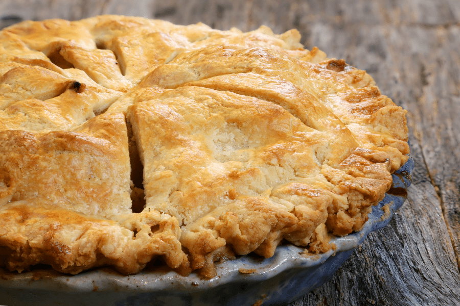 flaky apple pie on a wood table