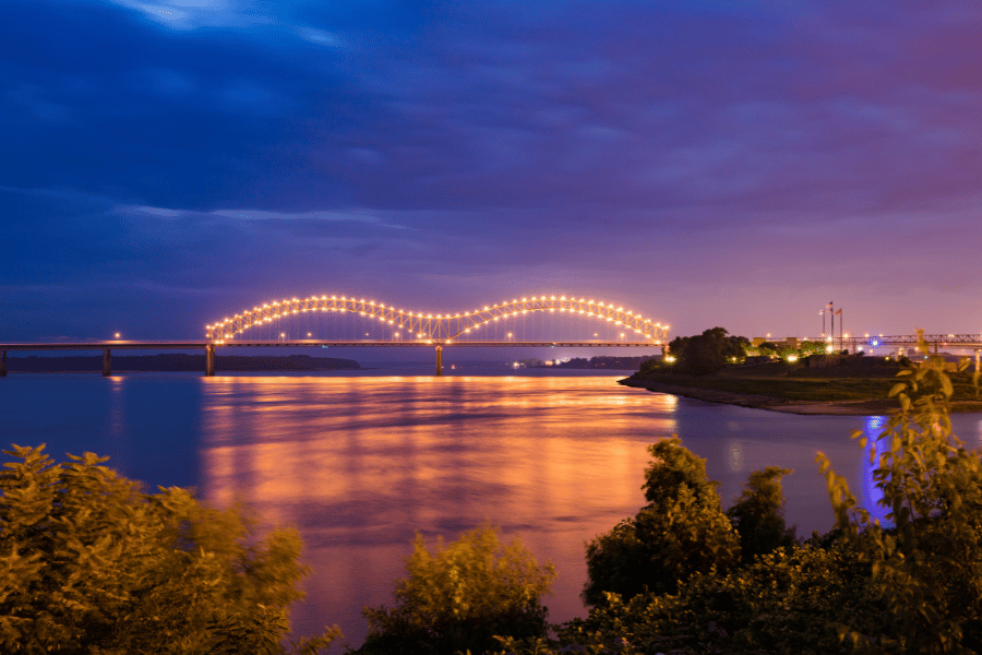 Memphis bridge lit up at night near the water 