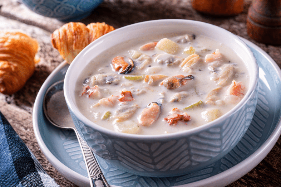 Big bowl of seafood chowder in a blue bowl 