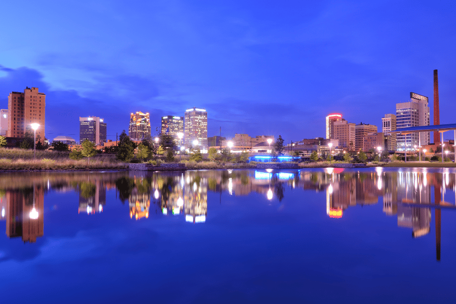 Birmingham, AL skyline at night with building reflections on water