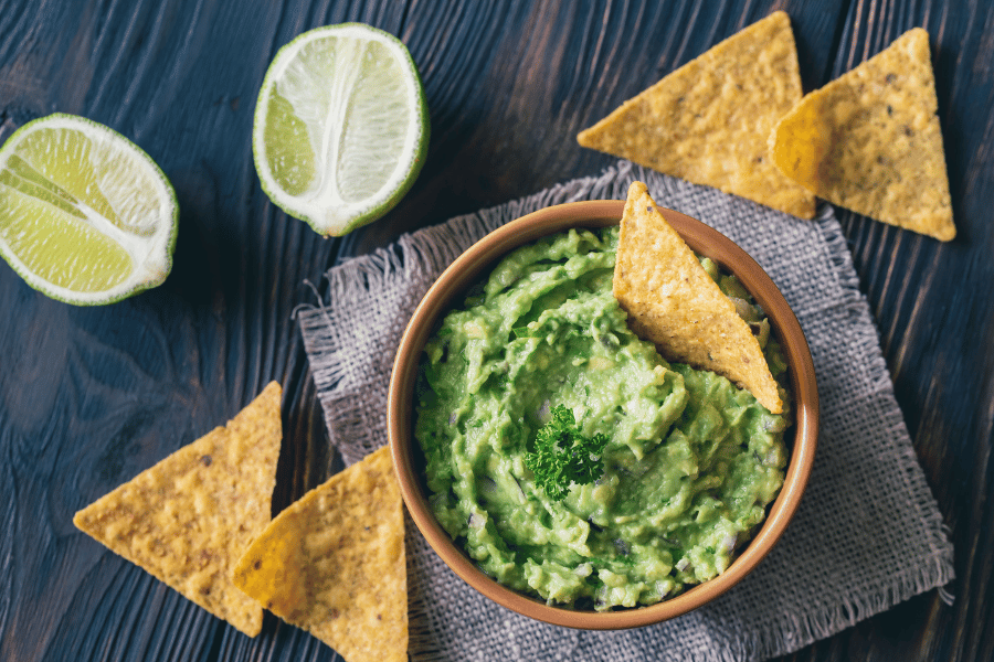 freshly made guacamole with chips and lime