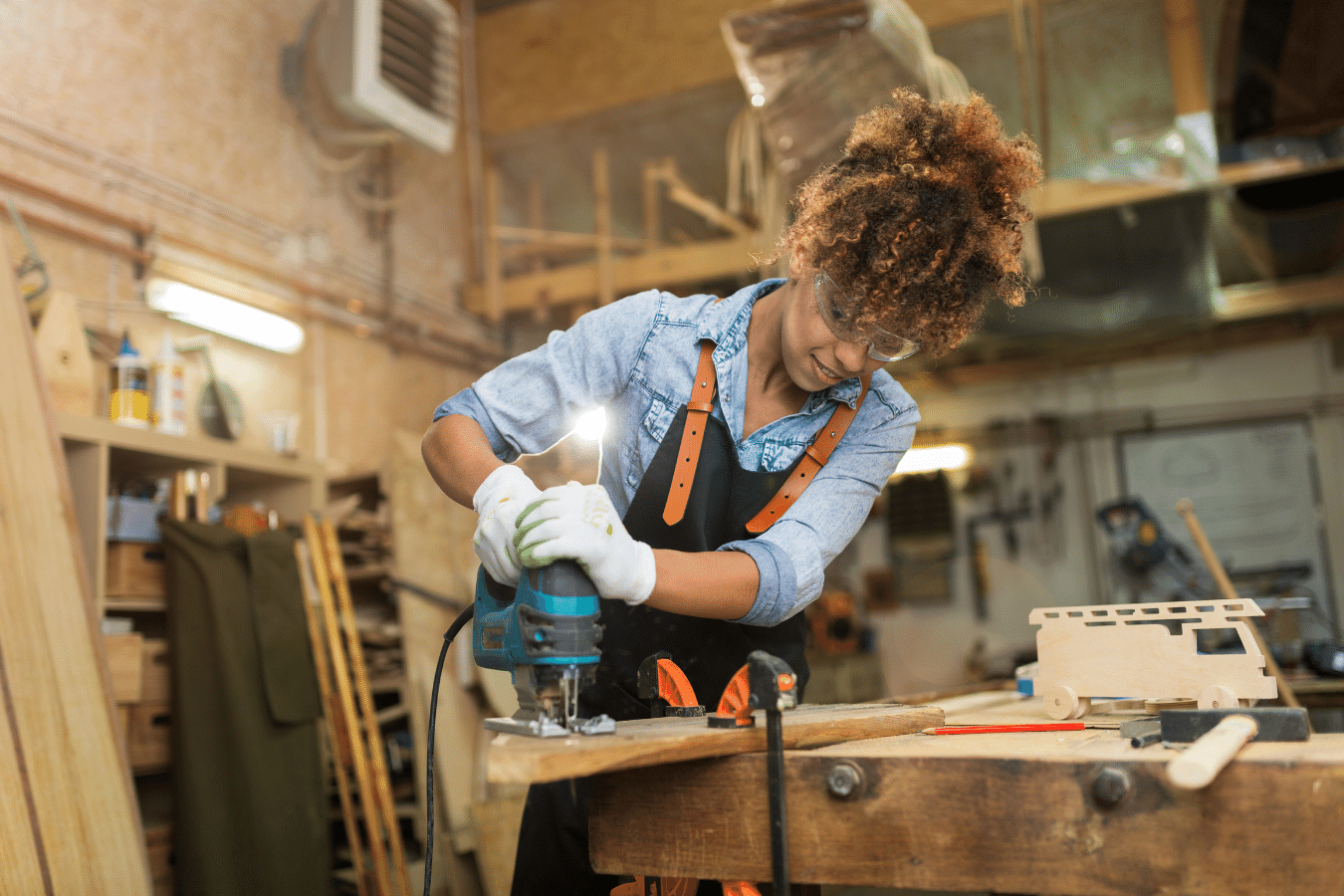 A woman working in her garage on woodworking