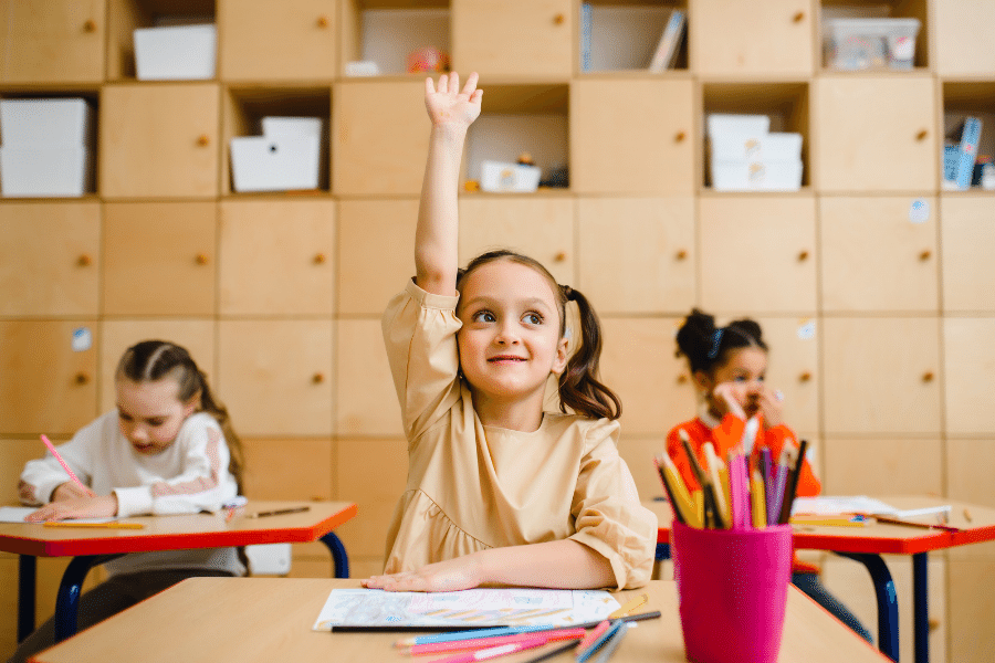 kid raising hand in class