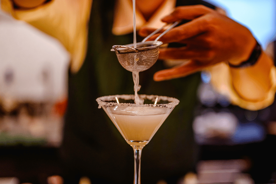 Barista mixing a cocktail in a glass 