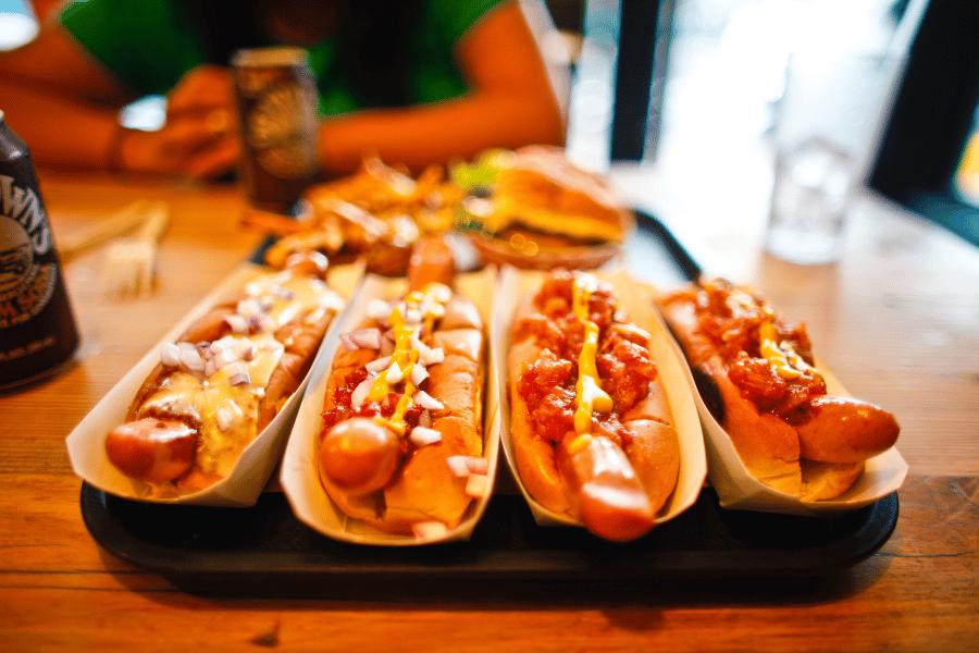 four hot dogs with toppings