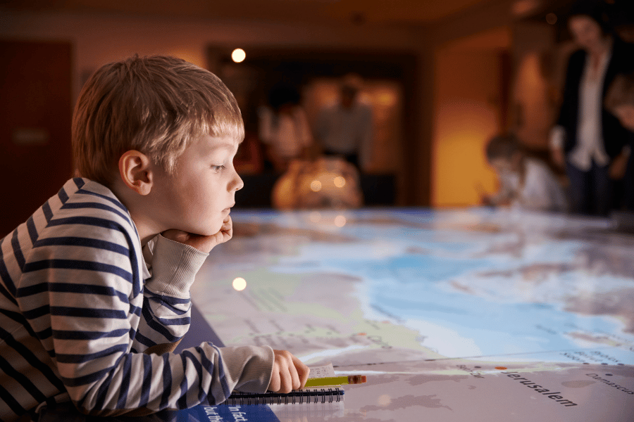 child at a children's museum looking at a map