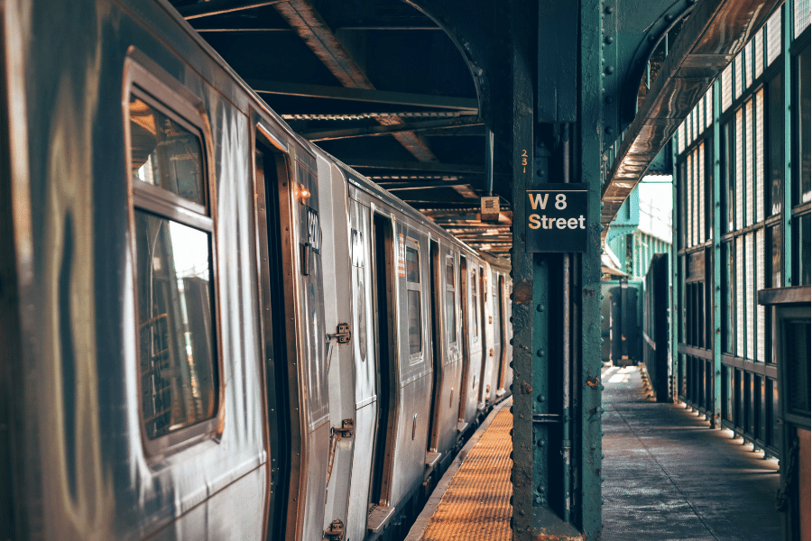 The shiny subway in Manhattan with gates and a sign that says W 8 Street