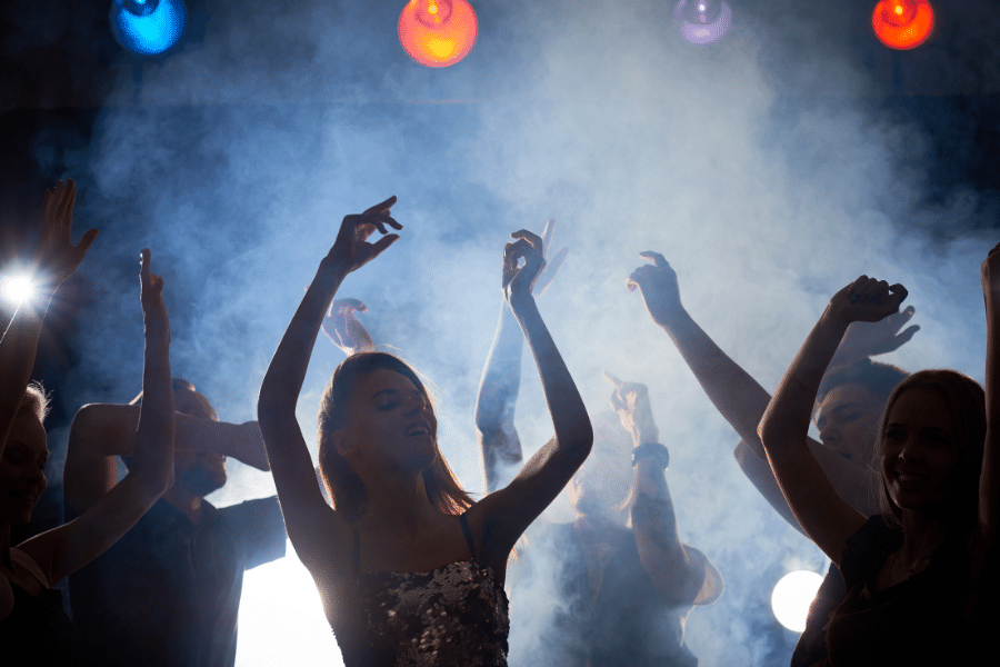 Group of people dancing with bright lights 