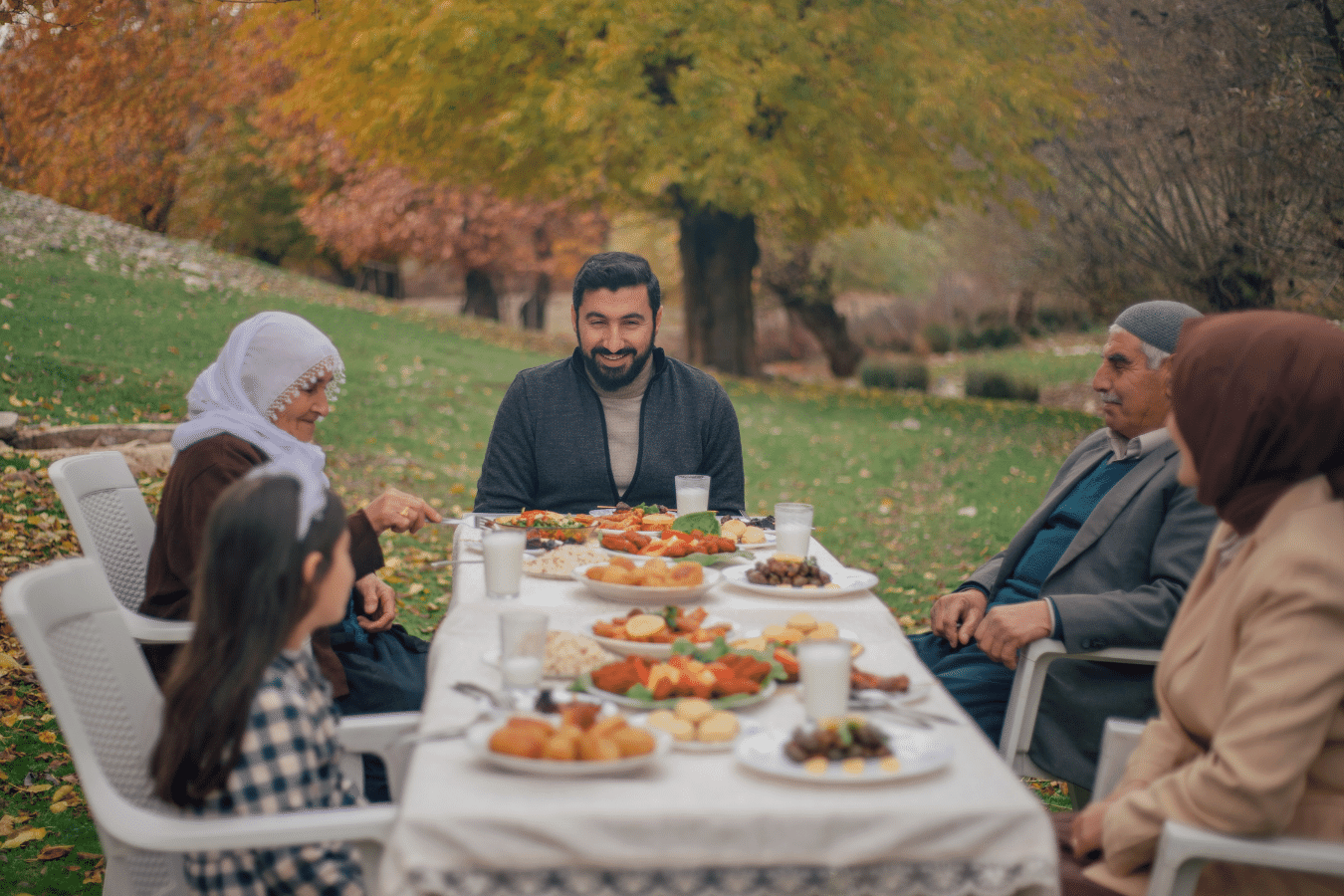 Family outside eating dinner together with multiple generations