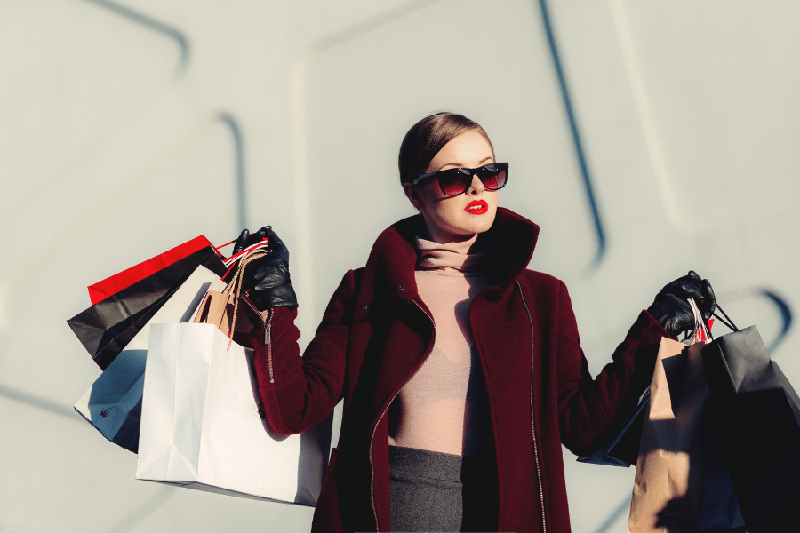 woman with big sunglasses shopping with shopping bags 