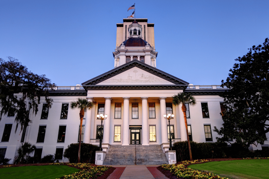 Florida State Capitol Building in Tallahassee, FL white building and well-manicured lawn
