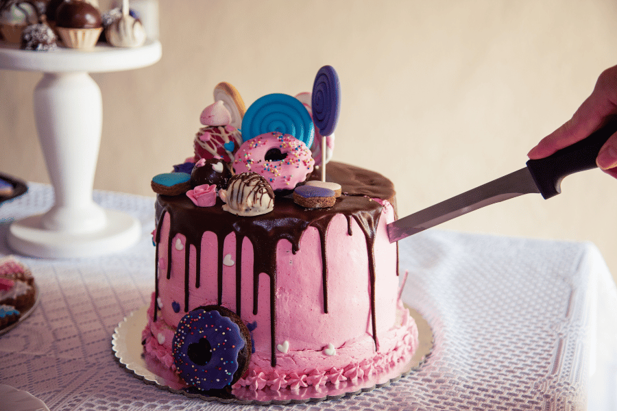 Pink cake decorated with ganache and donuts 