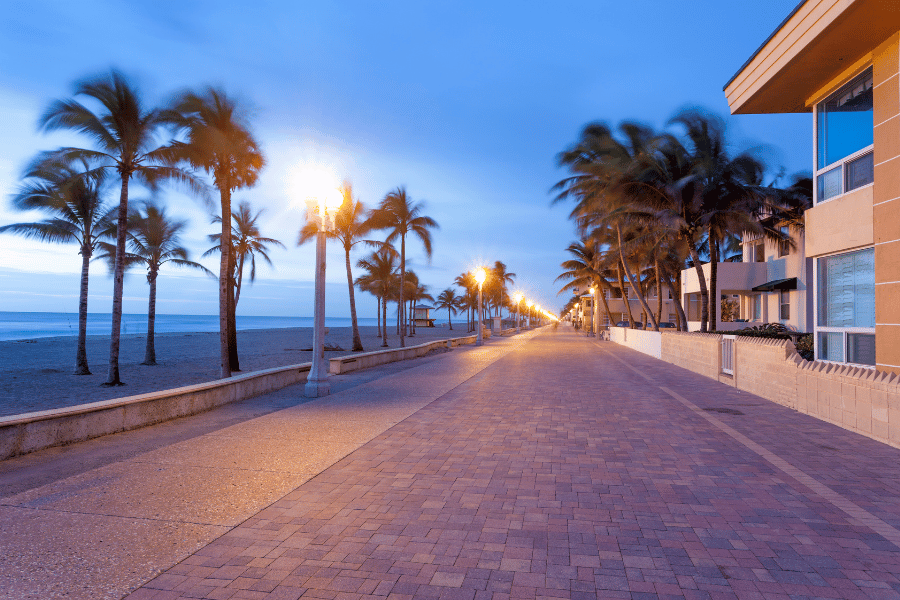 Hollywood Beach Broadwalk in Hollywood, FL at dusk with street lamps and palm trees