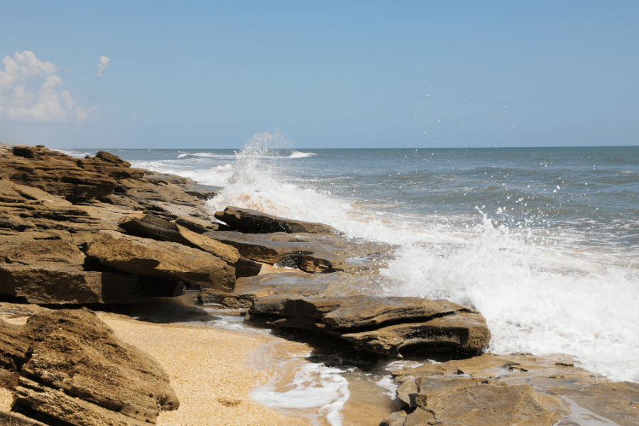 Waves crashing on coquina rocks on the beach 