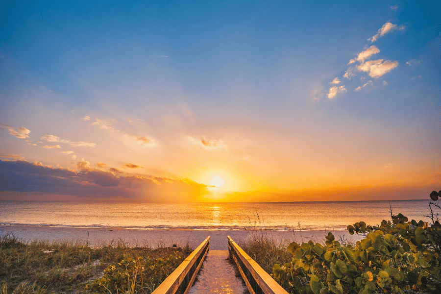 Image of the beach and ocean from a boardwalk at sunset