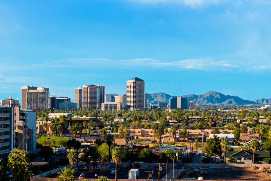Chandler, AZ on a sunny day with palm trees, buildings, and mountains in the background