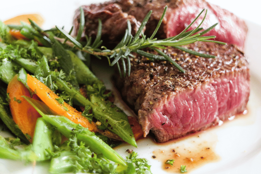 Steak dinner with vegetables on a white plate 