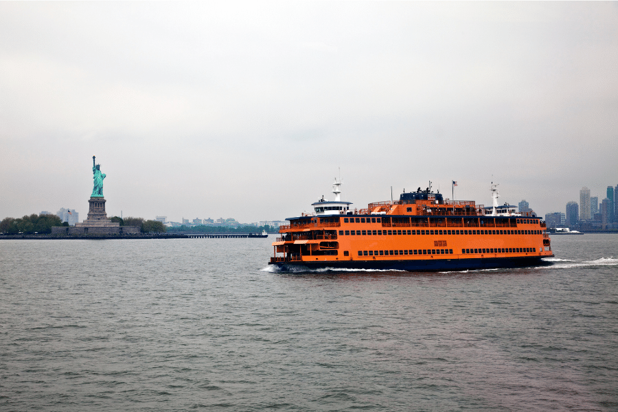 The Staten Island Ferry on a cloudy day with the Statue of Liberty in the background