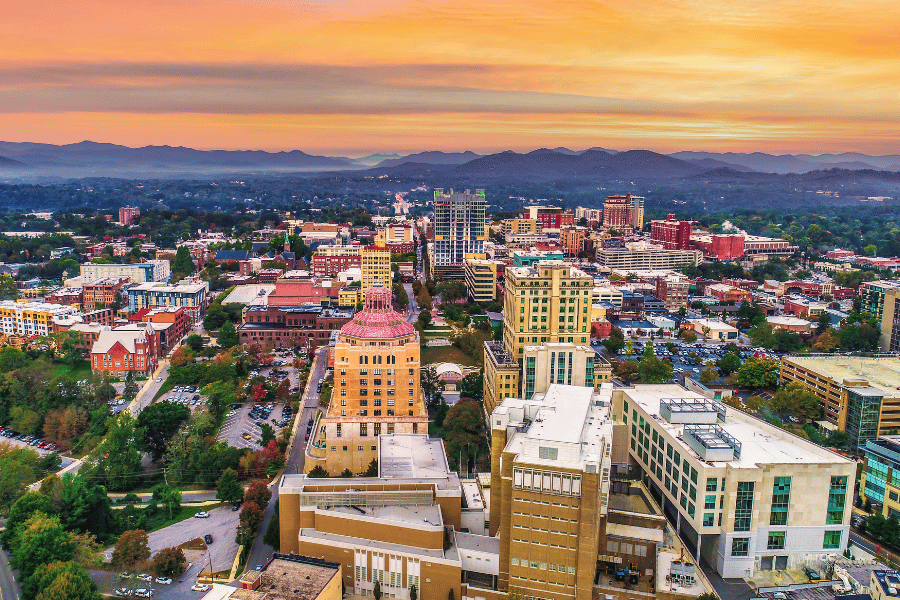 View of Asheville historic downtown with mountains in the sunset in background