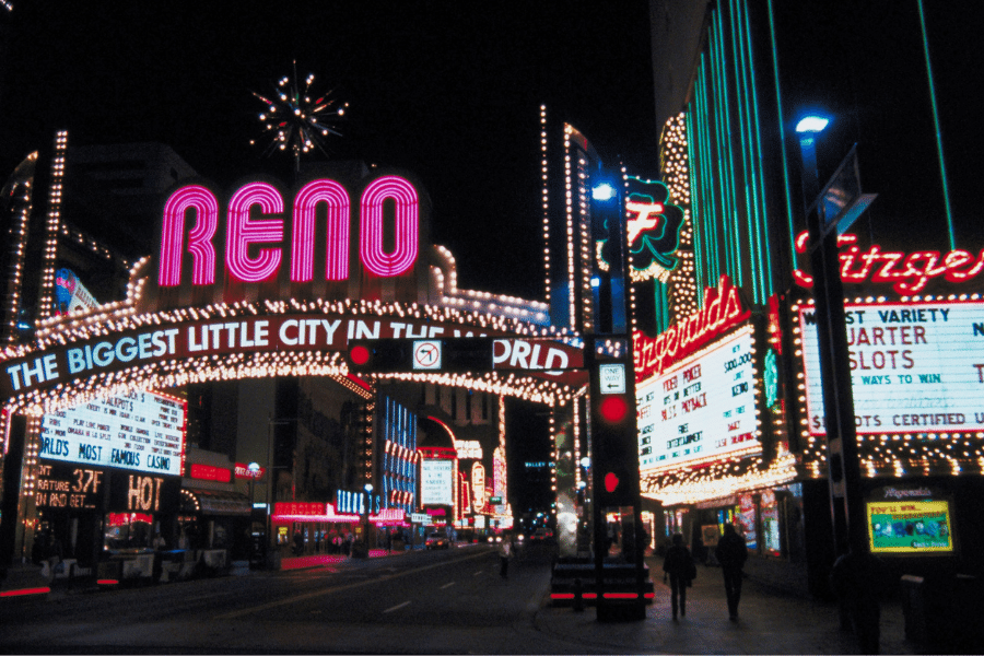 Reno, Nevada at night with bright neon lights people walking on the sidewalk