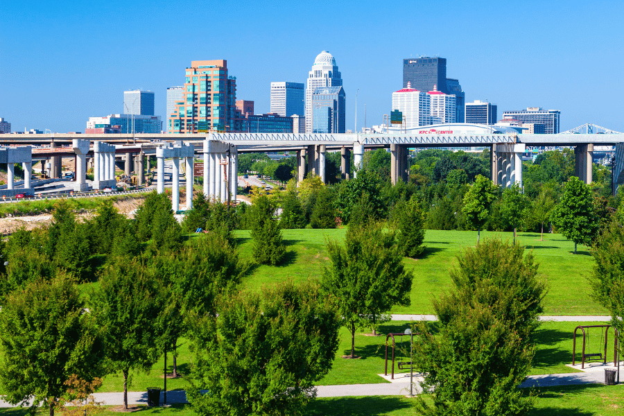 Downtown area view from green trees and grass in Louisville KY