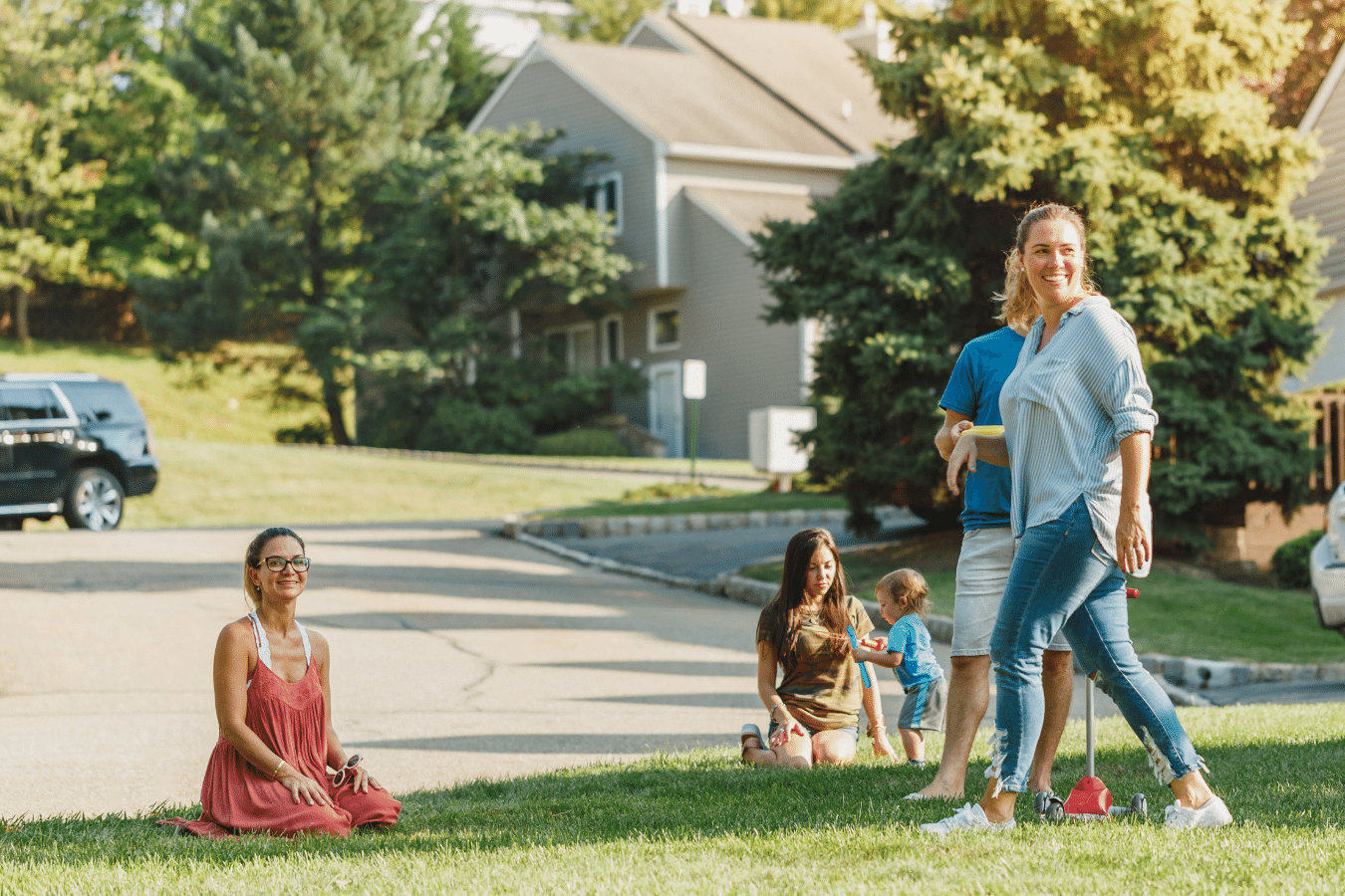 A neighborhood community with people and children outside playing