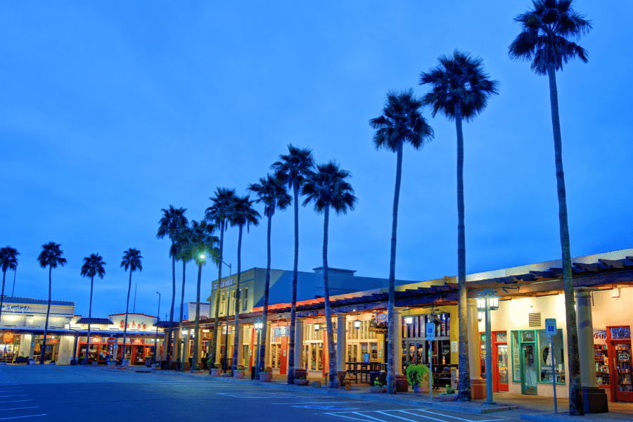 Shopping center at night in Chandler, AZ with palm trees and an empty parking lot