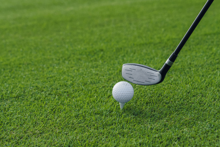 golf ball sitting on a tee with a golf club