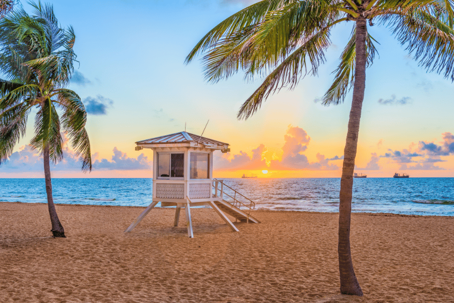 Beautiful beach in Fort Lauderdale, FL during sunset with palm trees and lifeguard stand