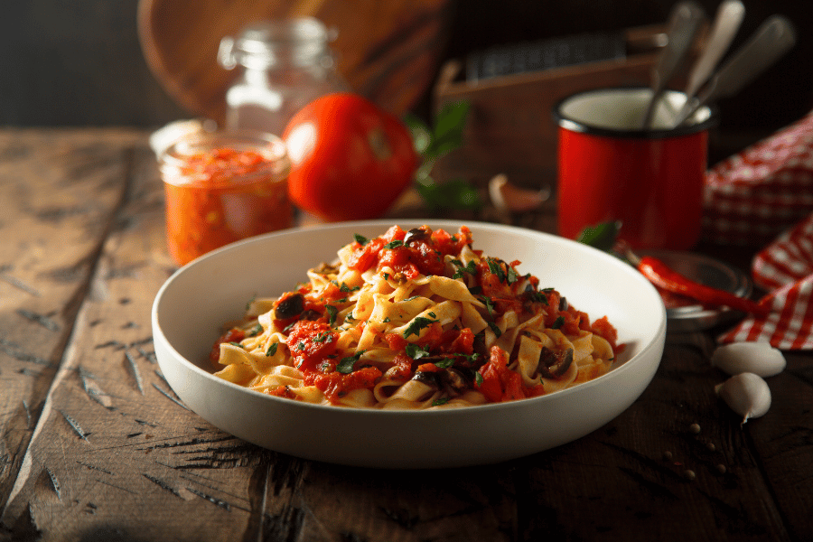 Italian pasta with red sauce in a white bowl 