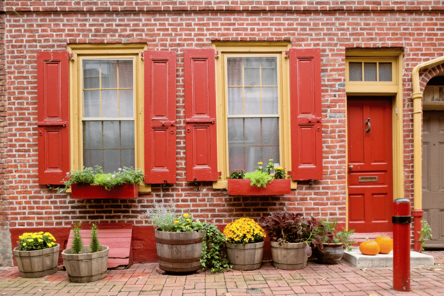 Image of the front of Philadelphia home with brick exterior and red shutters and door