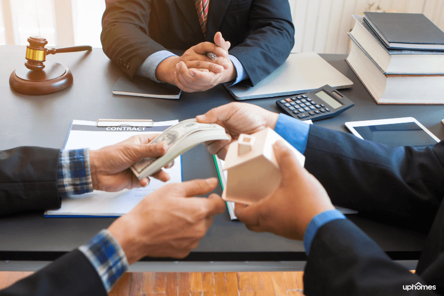 A Real Estate Attorney sitting at the closing table in a suit as the money is exchanged for the home