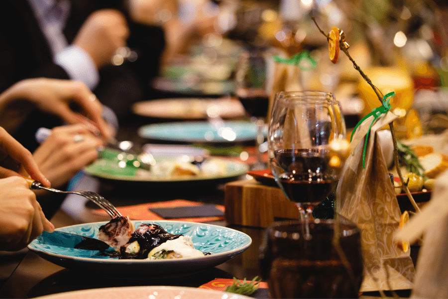 Diners eating at a restaurant with food and wine Diners eating at a restaurant with food and wine