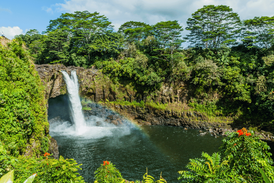 Hilo, HI Waterfall Beautiful waterfall and lush forest with rainbow in Hilo, HI