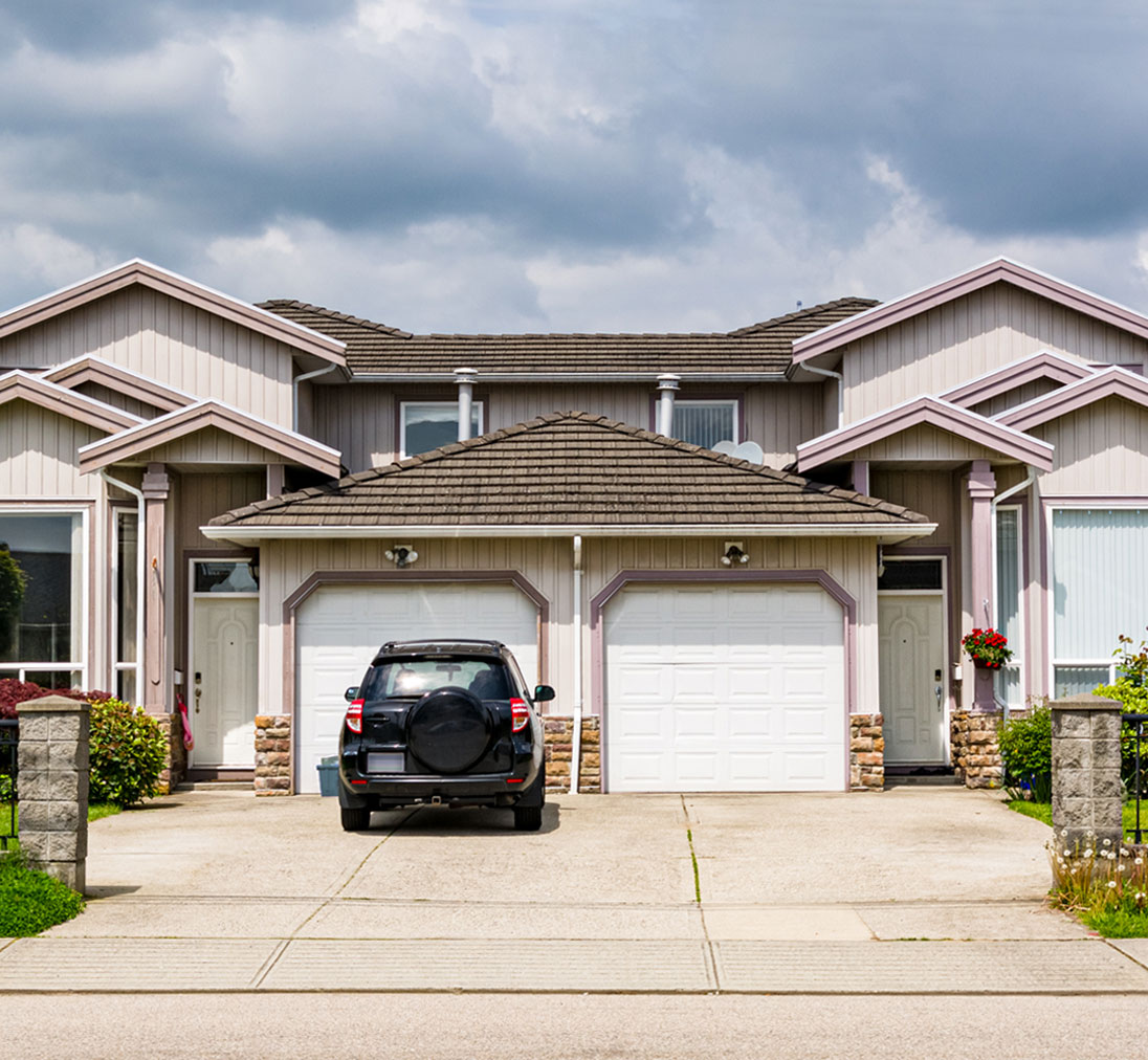 A car parked in front of a duplex multi family home