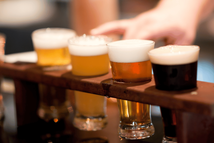 glasses of beer on a wood flight holder 