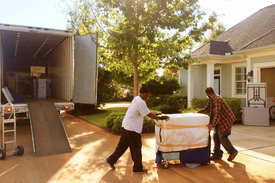 Movers moving furniture into new home moving truck