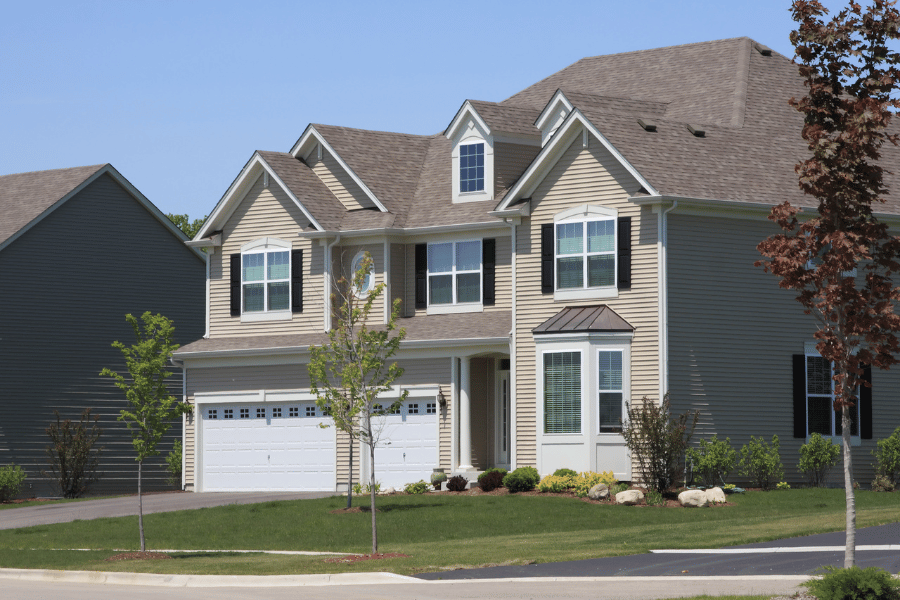 Single-family home for sale in the suburbs with green landscaping and trees
