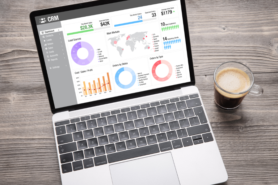 Laptop-with-CRM-Software.png CRM software on a laptop with a wood background and a cup of coffee