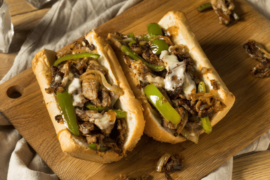 Photo of a Philly cheesesteak from above on a wooden cutting board