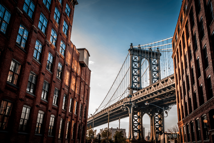A photo of the Brooklyn Bridge at night time with the bright city lights